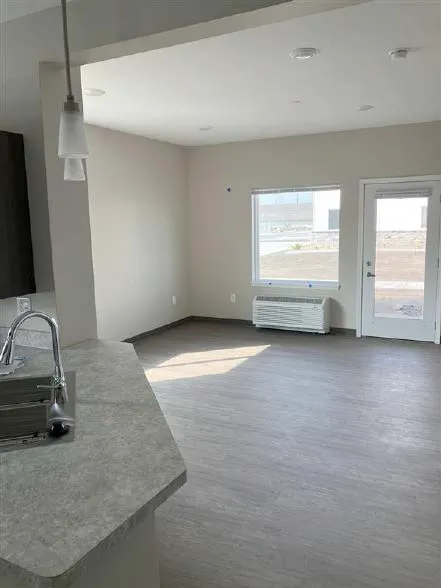 Bright, open living area with large windows and a door leading outside, showcasing a clean, contempo.