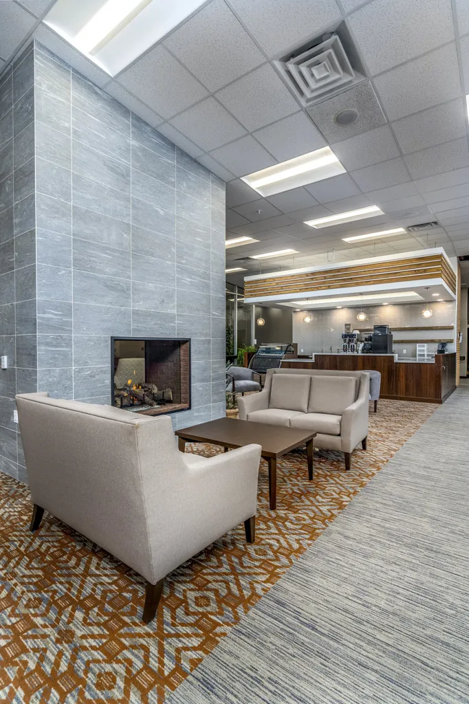 Modern office lobby with seating area and fireplace at CR Builders.