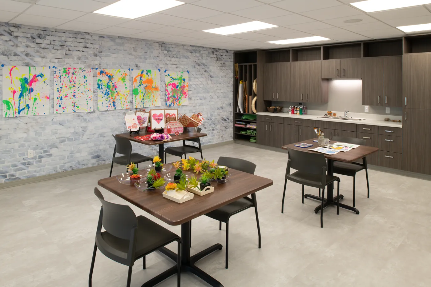 Community room with colorful artwork, tables, and a kitchenette for events and meetings.