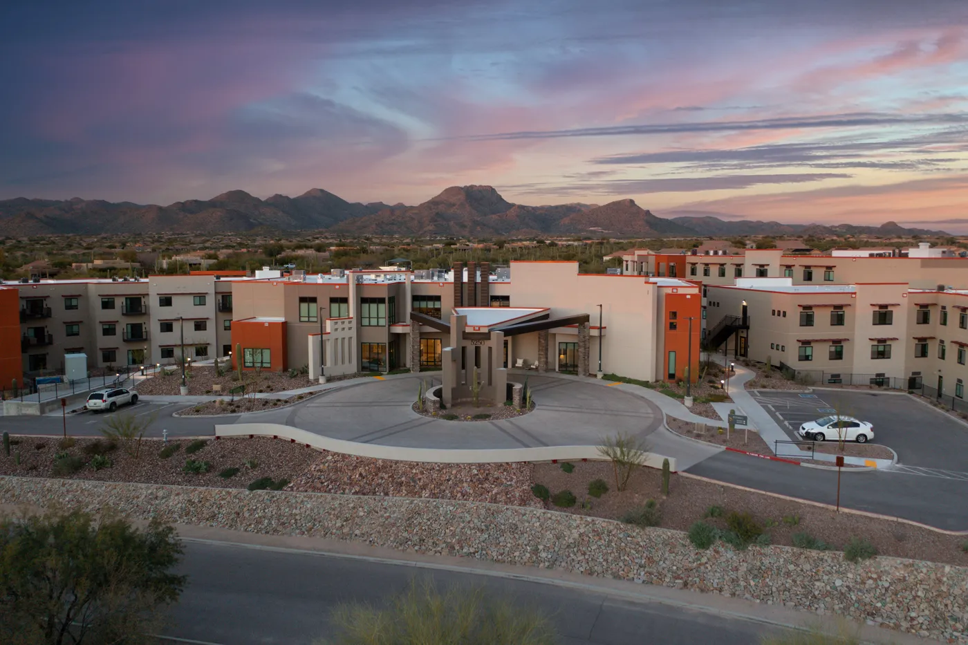 Beautiful residential complex featuring contemporary homes and scenic mountain backdrop at dusk.