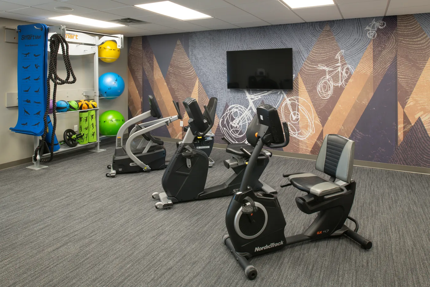Exercise bikes and fitness equipment in a modern gym room at CR Builders.