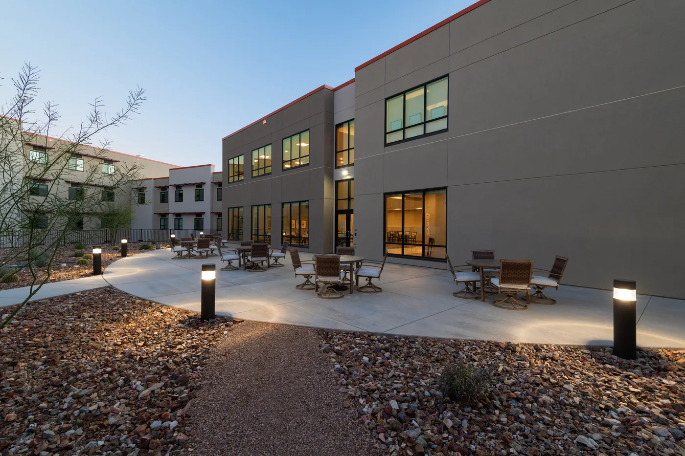 Modern residential building with outdoor patio and landscaping.