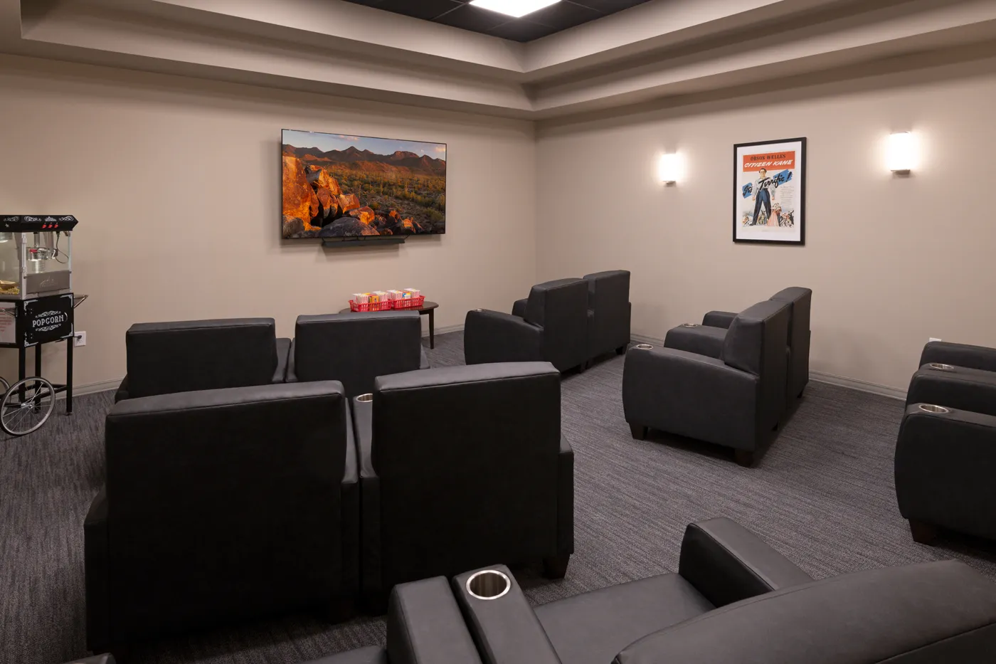 Office lounge with black chairs, artwork, and a coffee station for visitors.