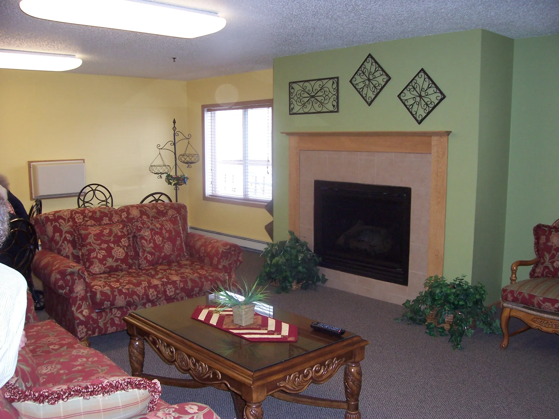 Cozy living room featuring a fireplace, vintage sofa, and decorative wall art for a warm, inviting a.