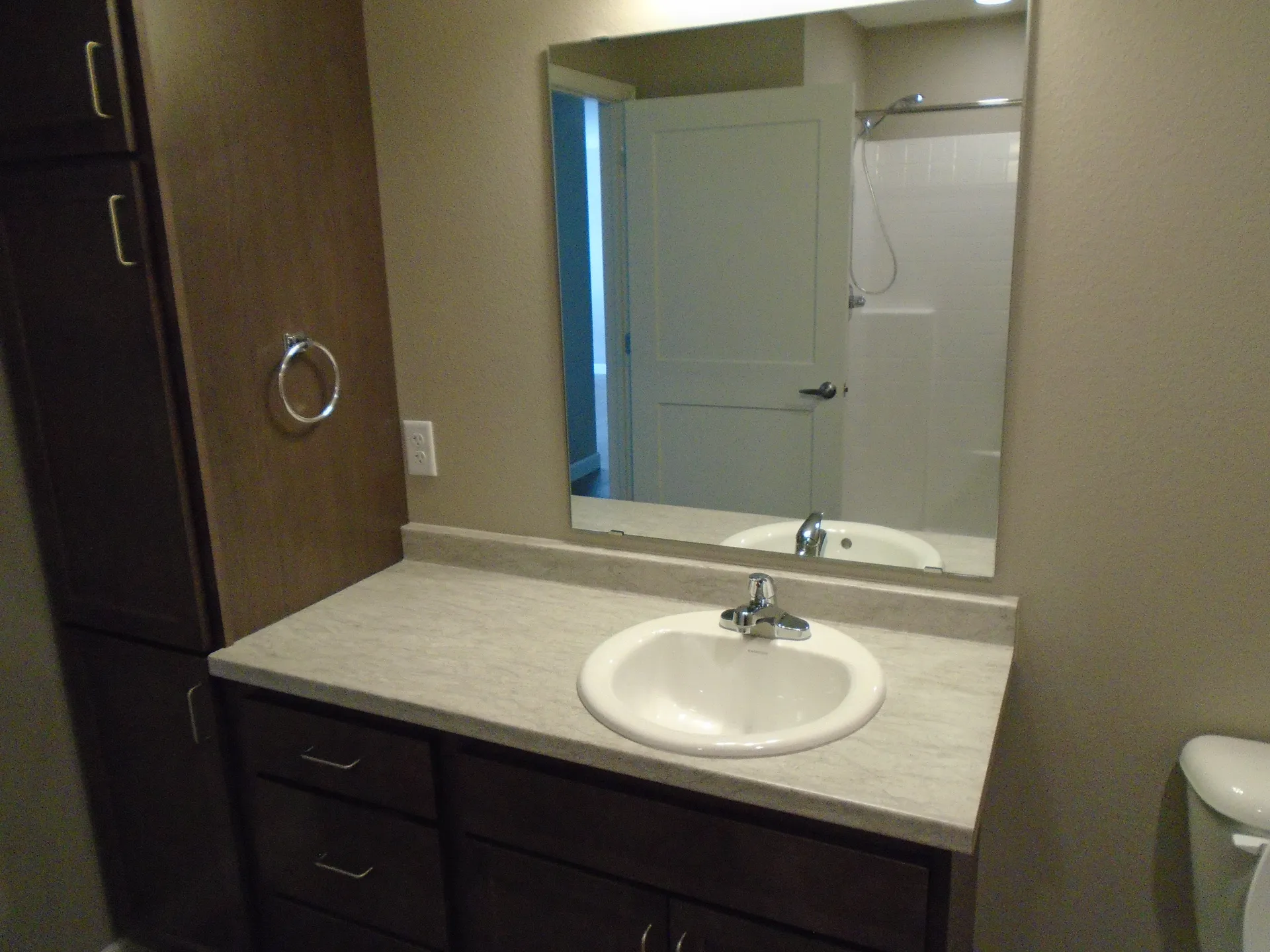 Bathroom vanity with sink, mirror, and storage cabinets in a contemporary home.