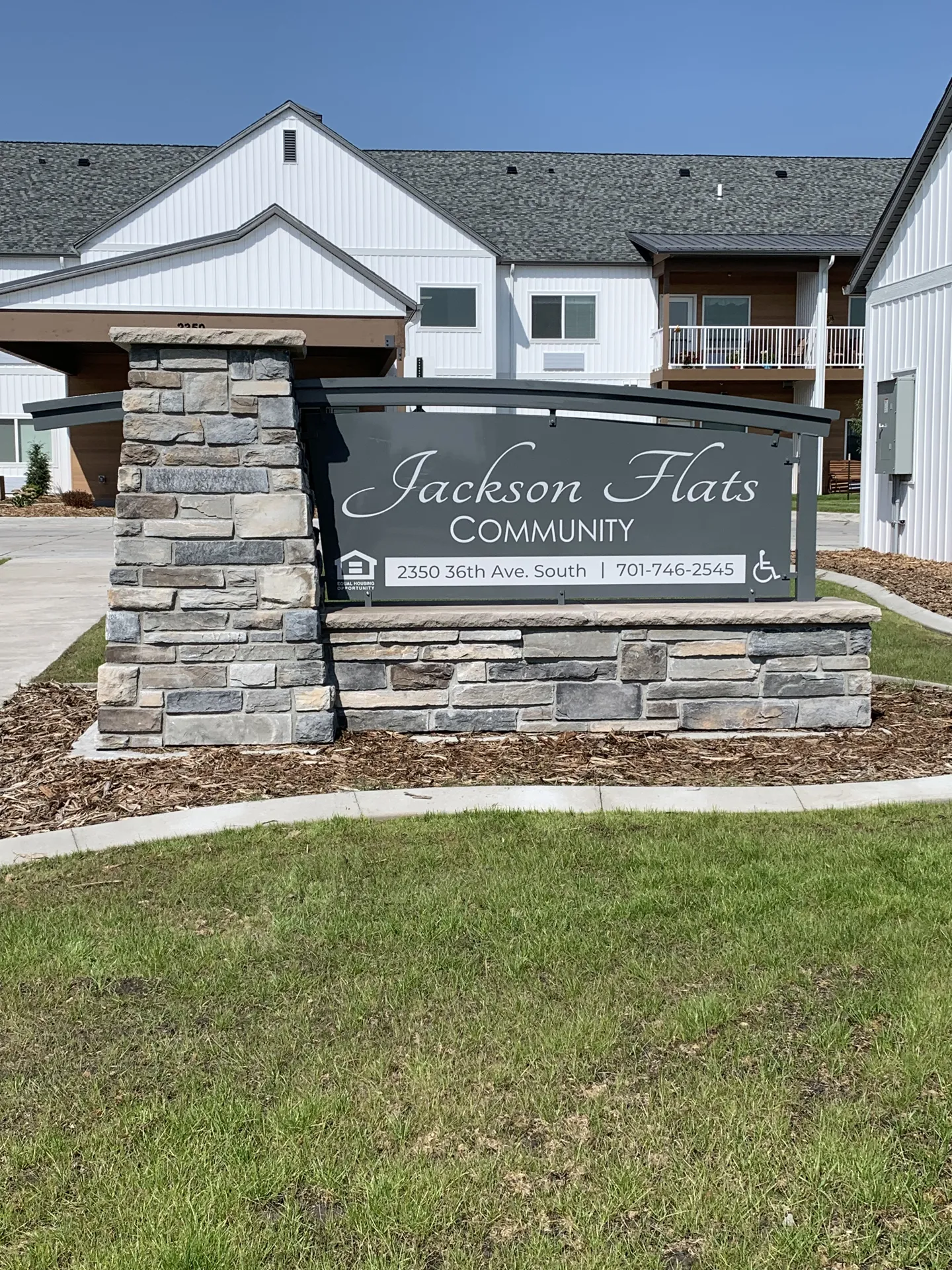 Community sign for Jackson Flats with stone base and modern design.