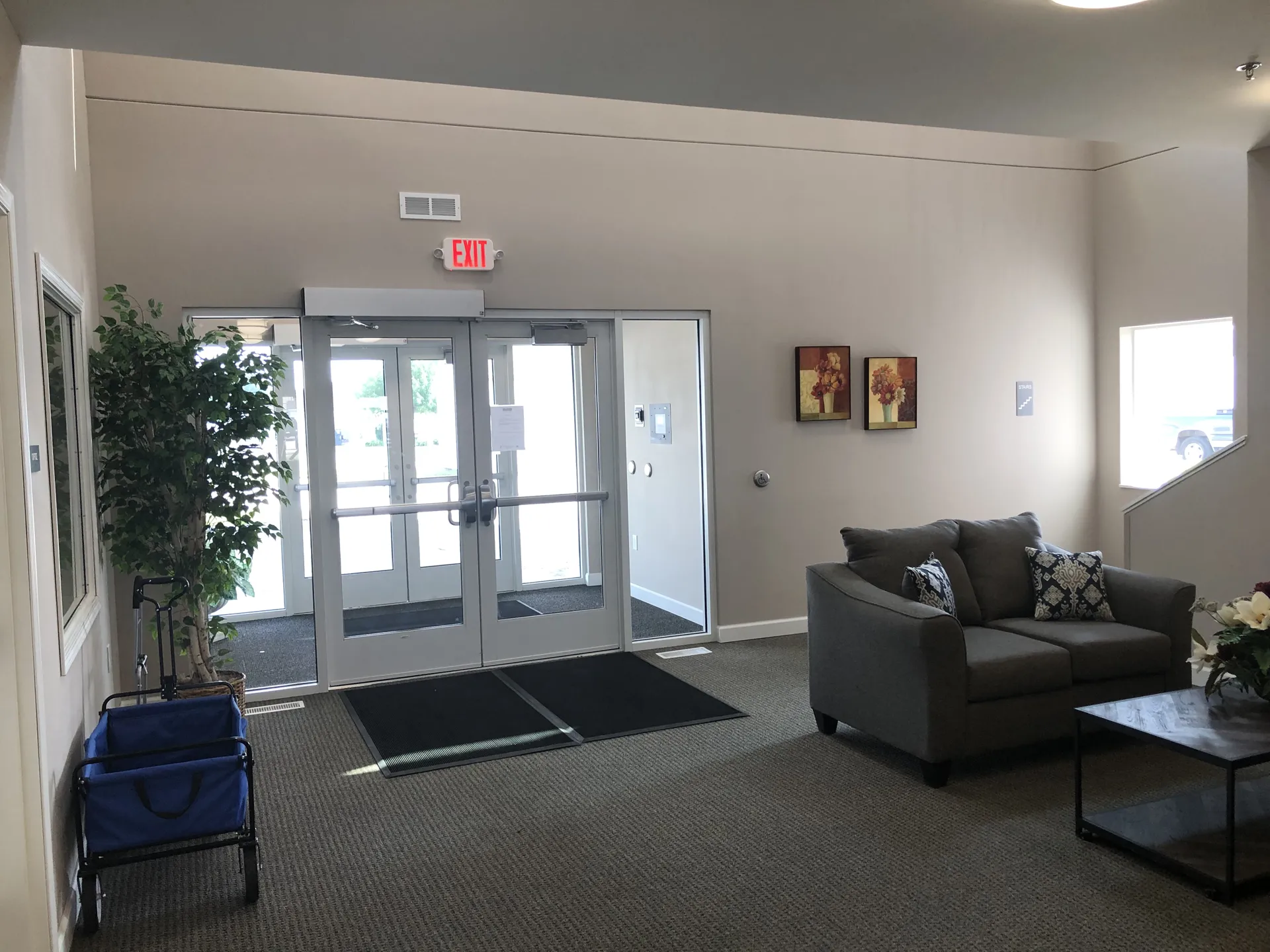 Modern building lobby with glass doors and seating area.