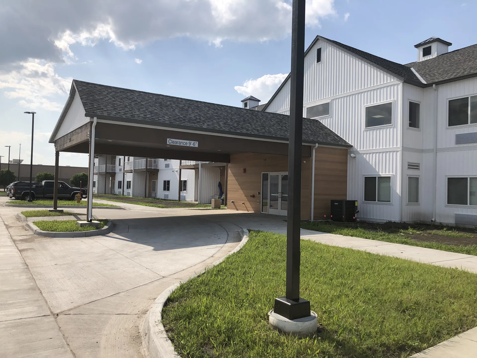 Apartment complex with covered parking and green lawns, showcasing quality construction and communit.