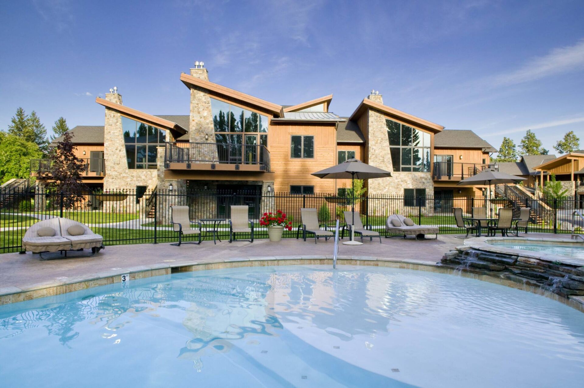 Luxury home with pool, outdoor seating, and landscaped yard.