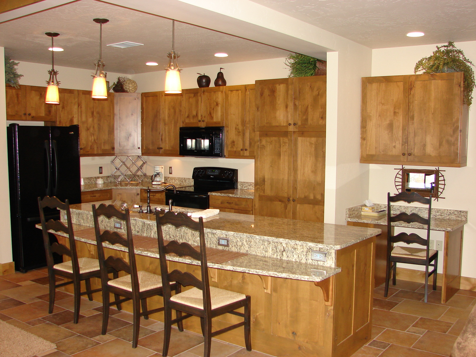 Kitchen with wooden cabinets, granite countertops, and modern appliances for a stylish cooking space.