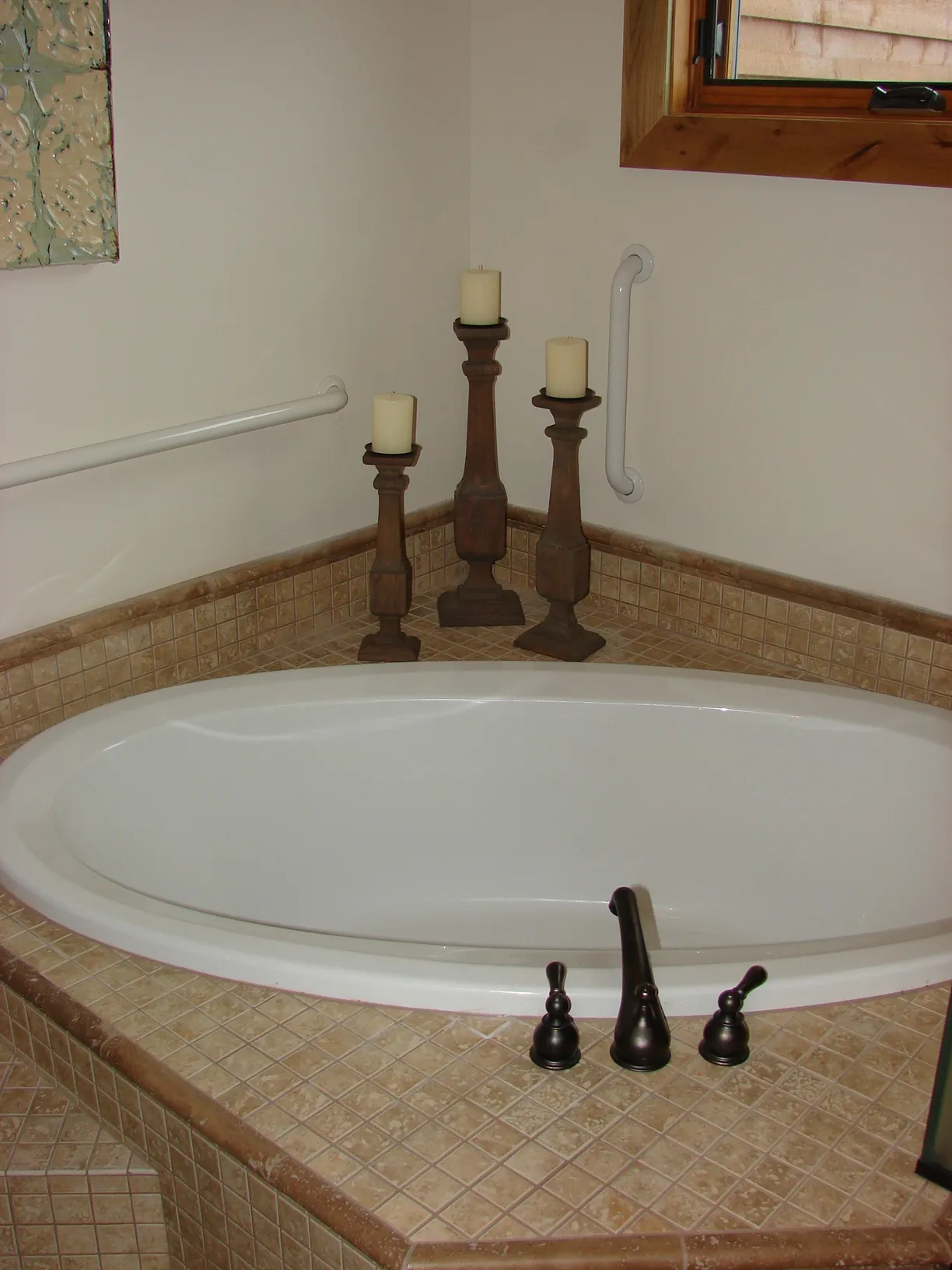 Bathtub with candles and wooden decor in a cozy bathroom setting.