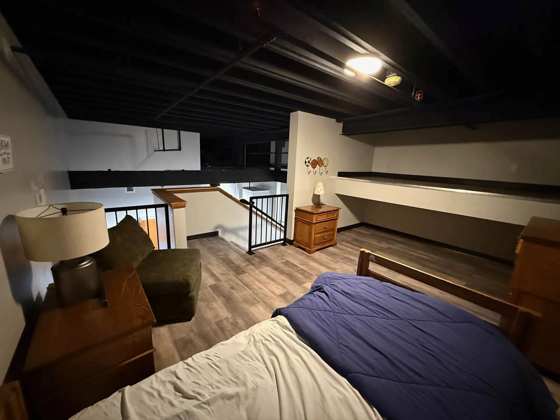 Comfortable bedroom featuring wooden furniture, cozy bedding, and modern decor in a stylish loft set.