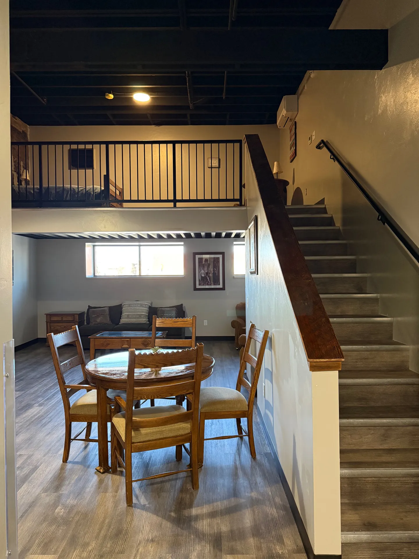 Interior dining room with wooden table and chairs, staircase leading to upper level, and cozy decor.