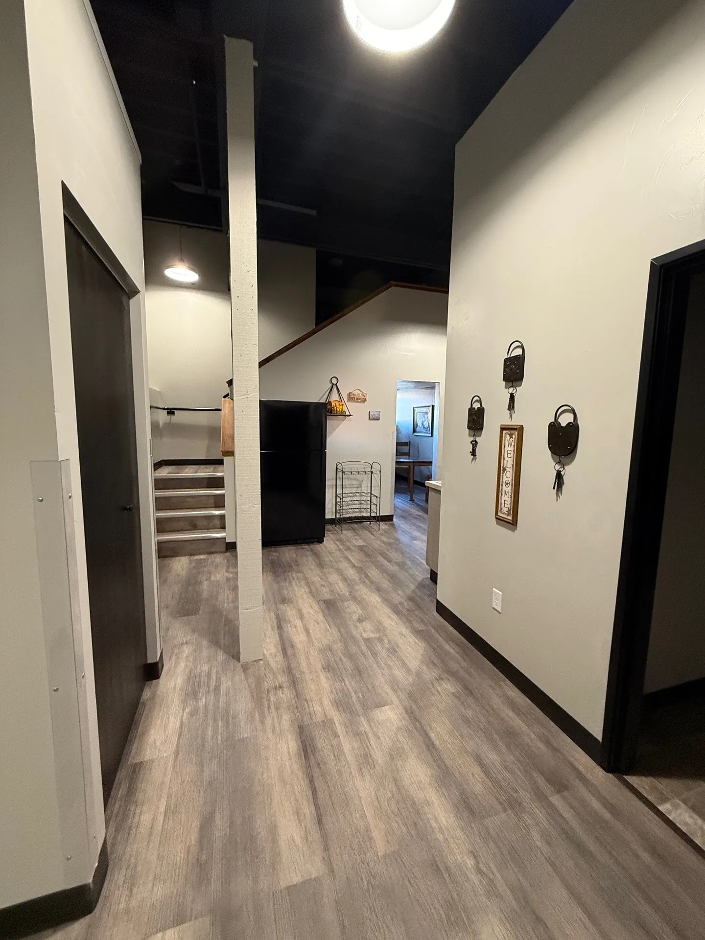 Elegant hallway with wood flooring, wall hooks, and modern decor in a contemporary home.