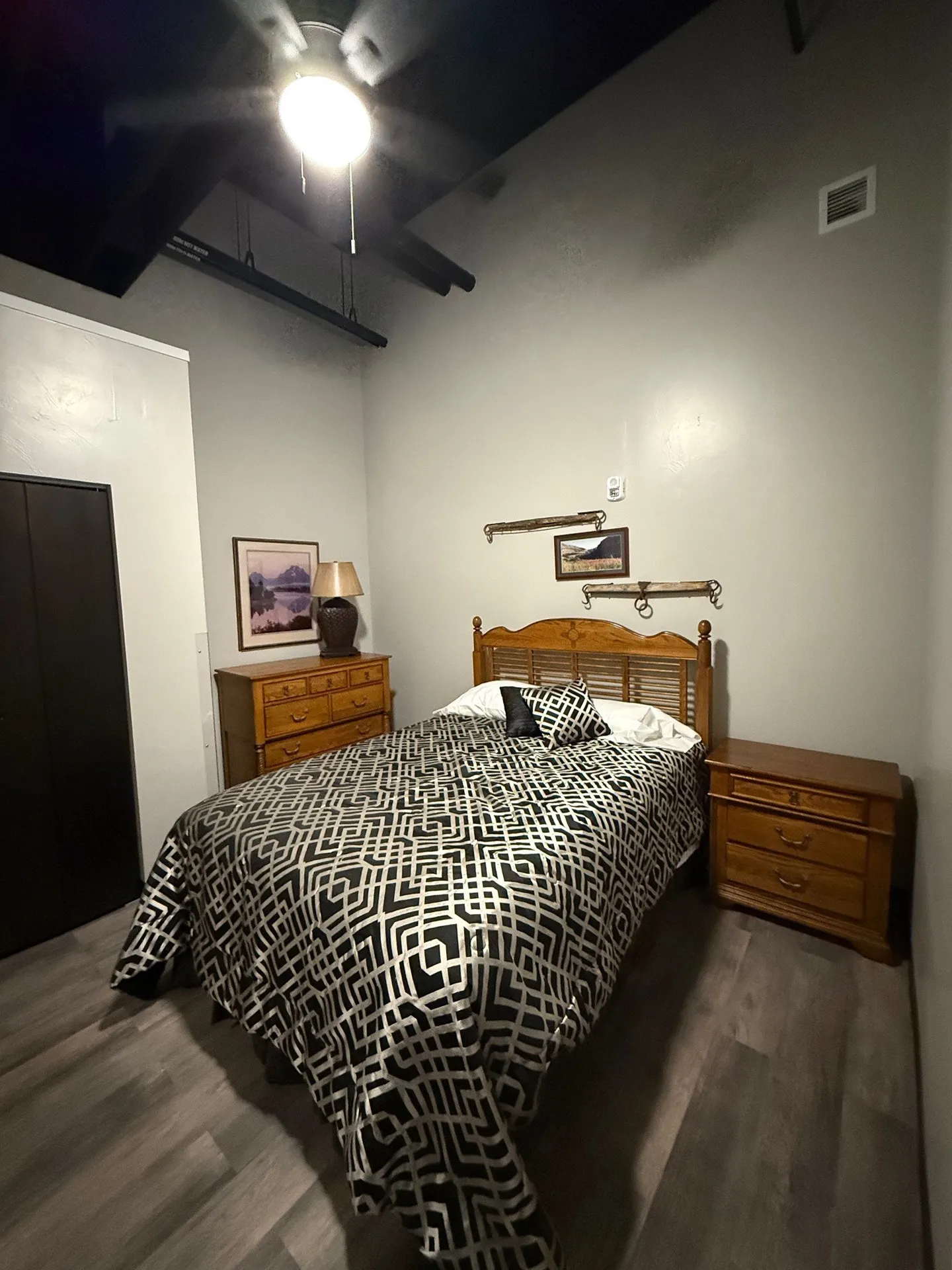 Modern bedroom with wooden bed frame, nightstands, and contemporary decor.