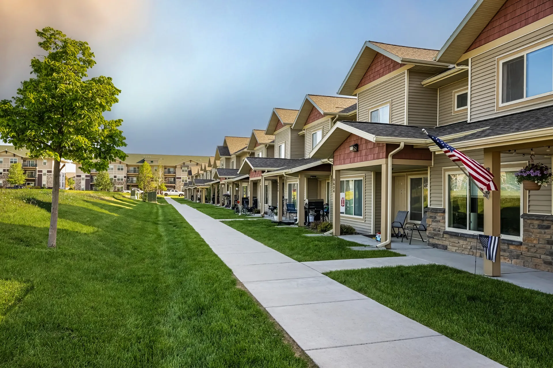 Beautiful suburban homes with manicured lawns and American flags in a peaceful community.