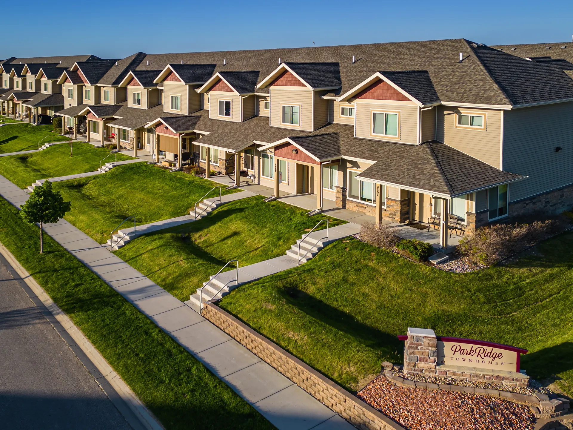 Townhouse community with landscaped lawns and walkways, showcasing quality residential construction.