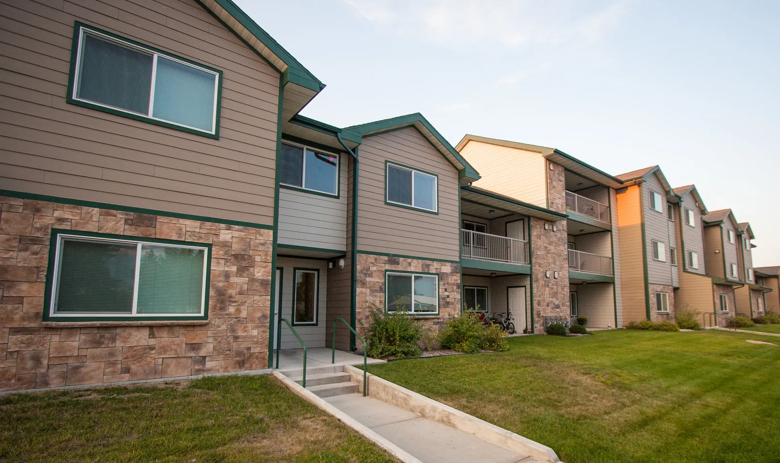 Modern apartment building with landscaped lawn and multiple units.