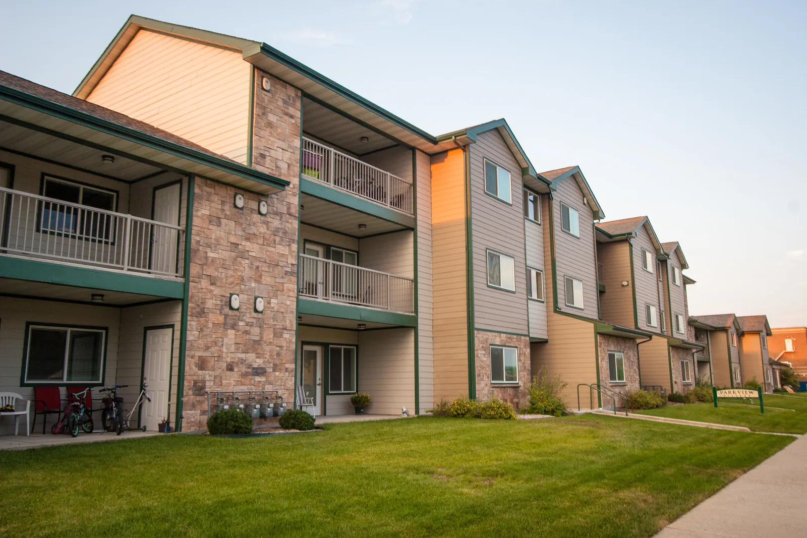 Apartment complex with landscaped lawn, outdoor walkways, and modern exterior design for comfortable.