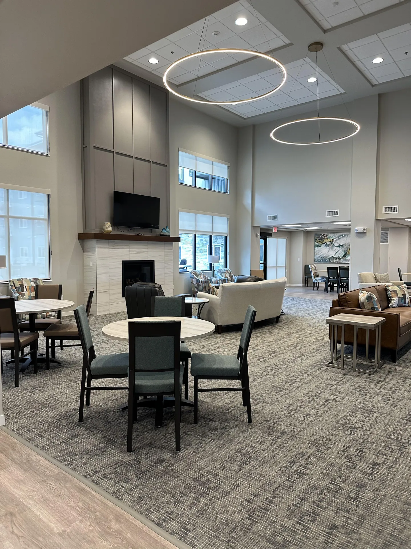 Spacious lounge featuring contemporary furniture, high ceilings, and large windows for natural light.