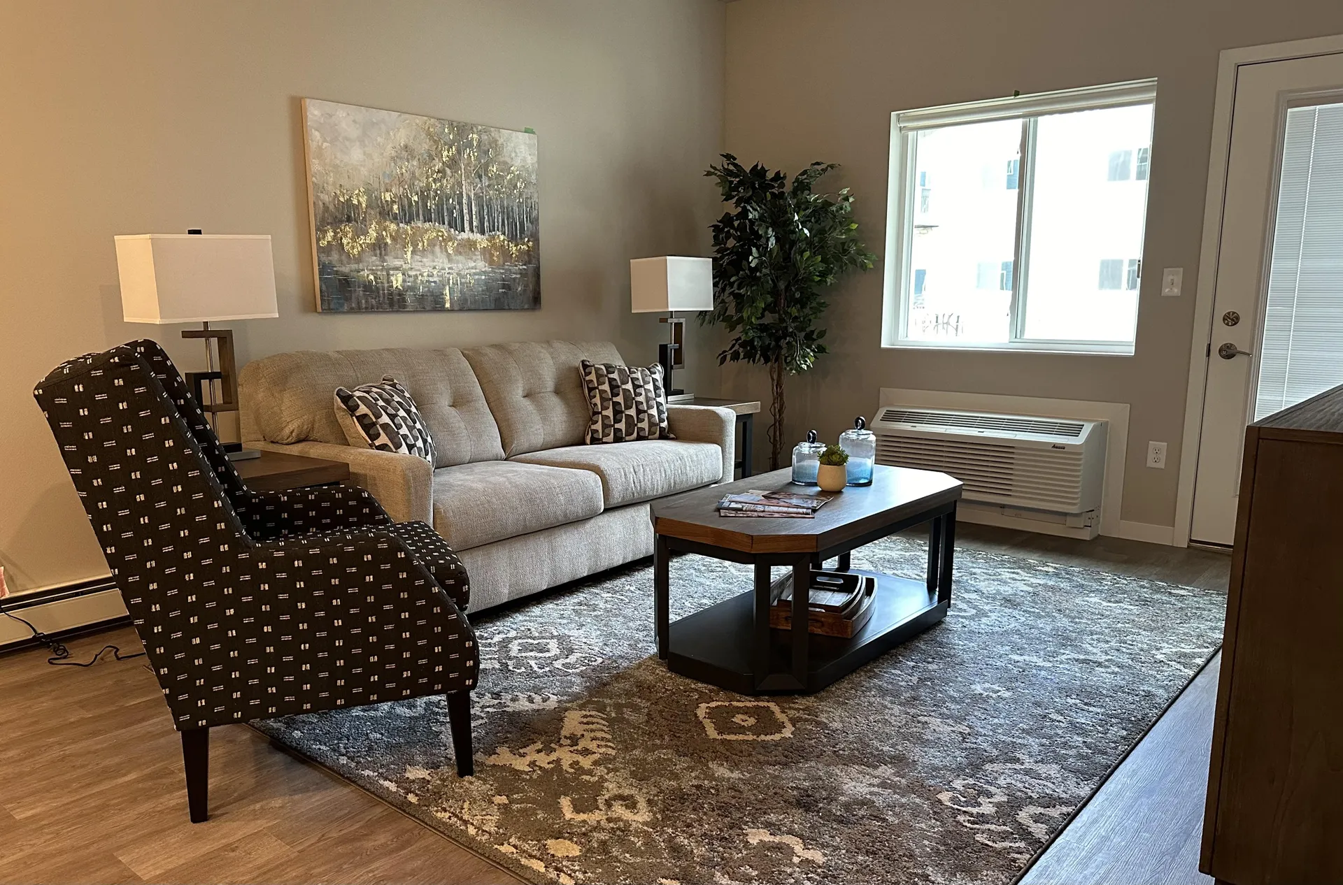 Cozy living room featuring a beige sofa, patterned armchair, and stylish decor in a bright, inviting.