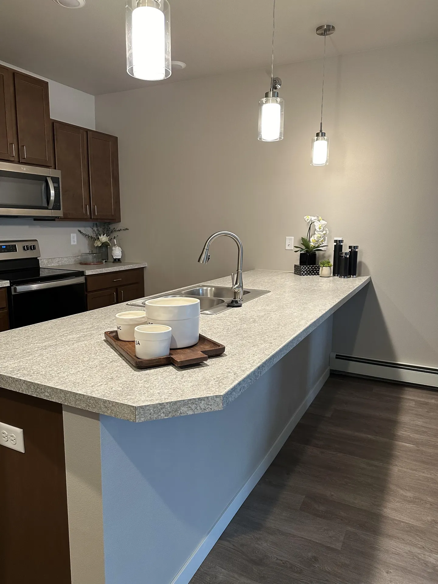 Kitchen with granite countertop, stainless steel appliances, and pendant lighting fixtures.