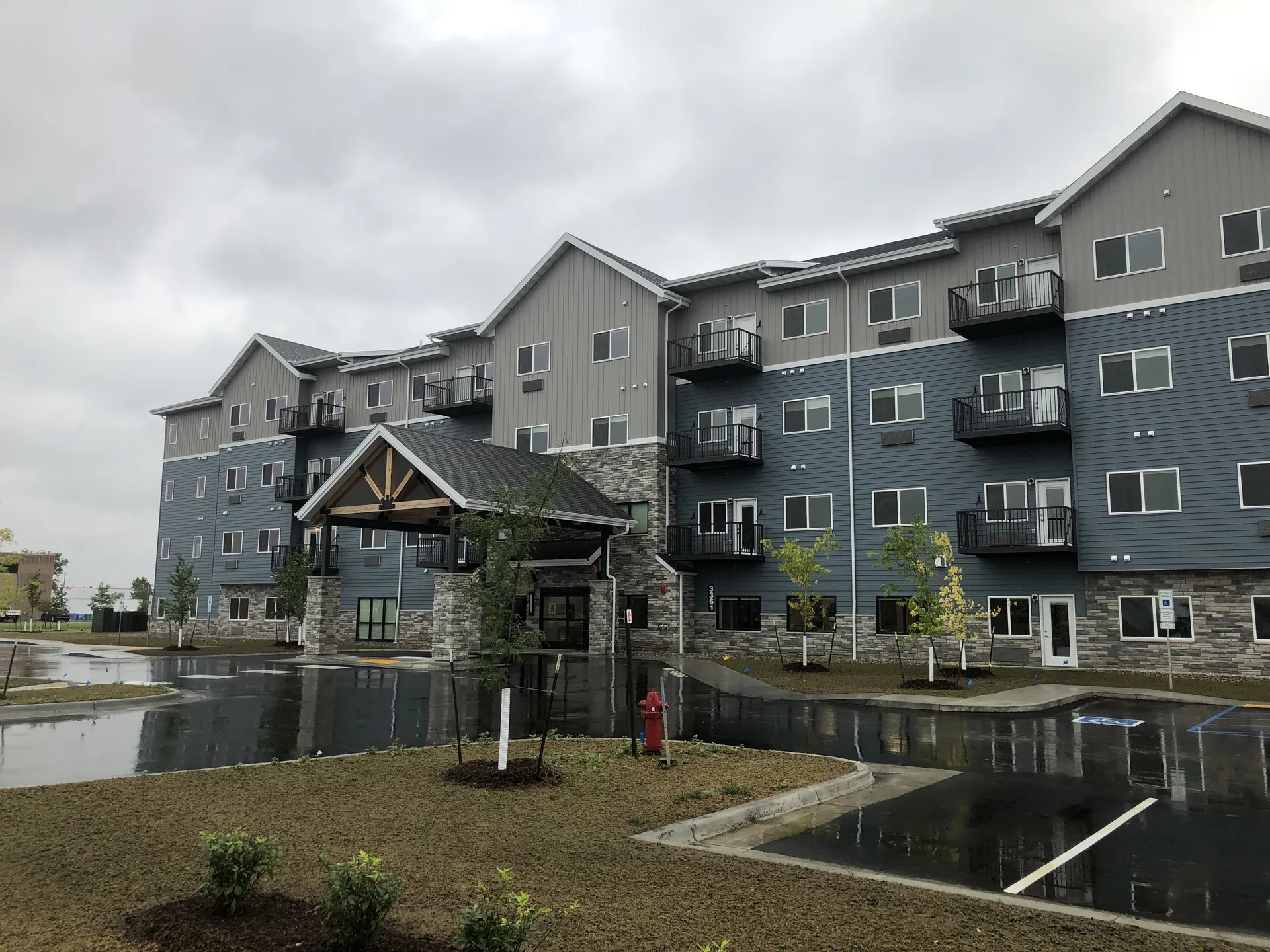 Modern apartment complex with balconies and landscaped outdoor areas.