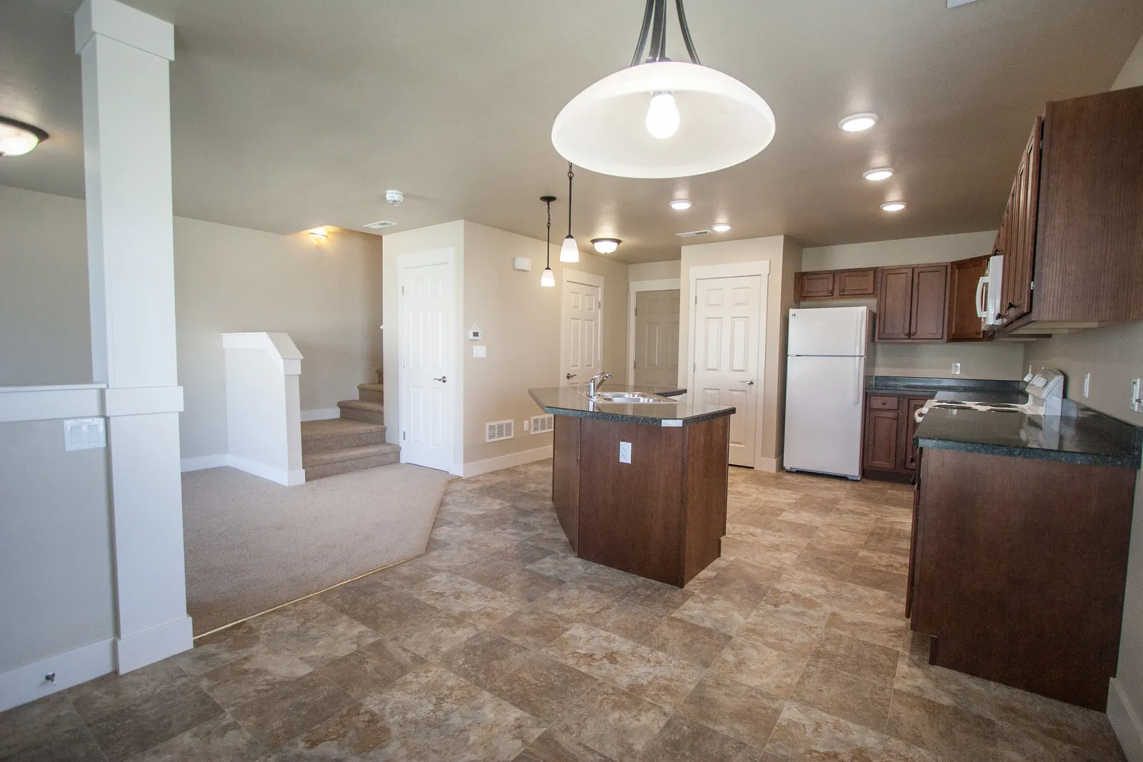 Modern kitchen with open living area, new appliances, and stylish finishes.