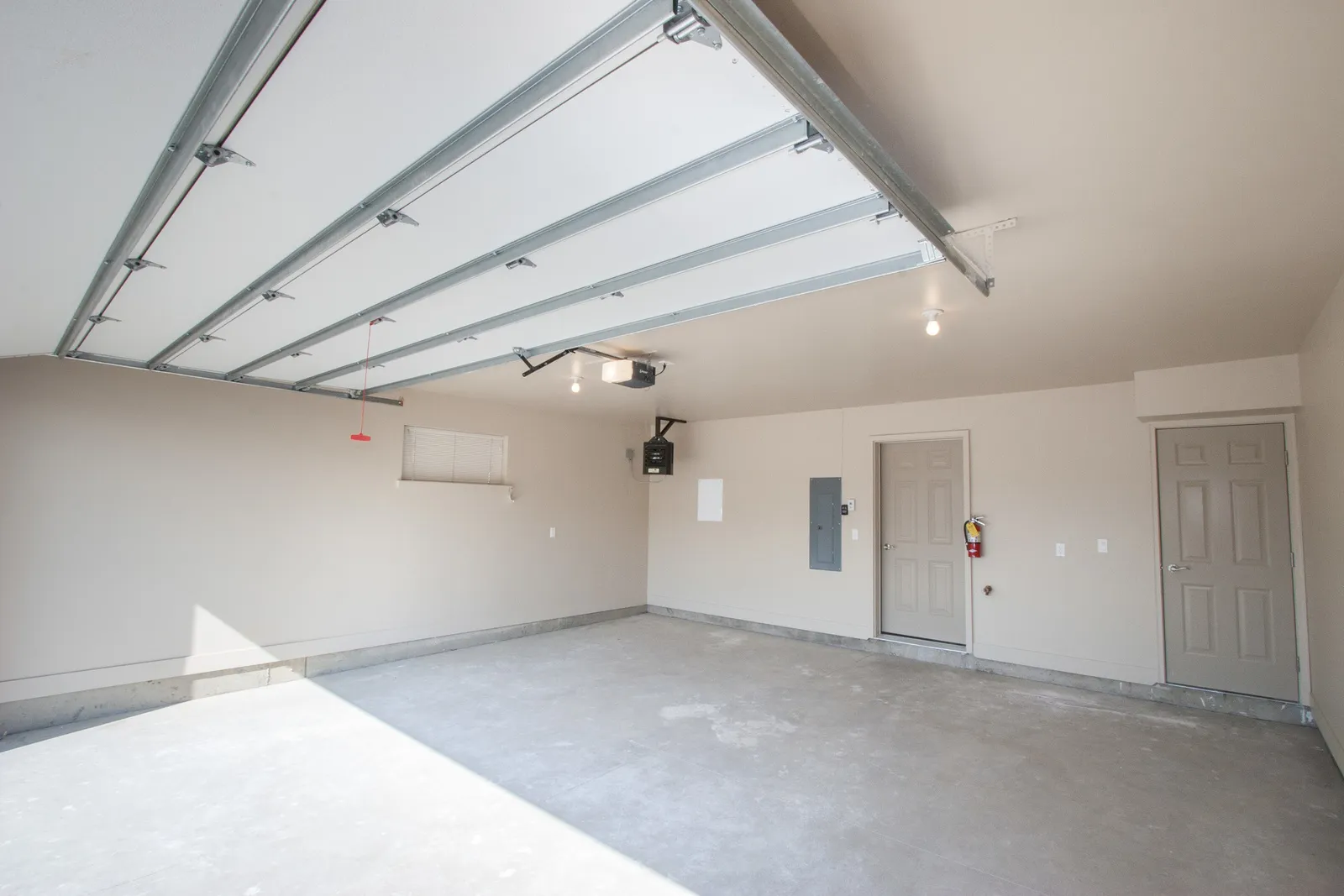 Garage with open door, showcasing a spacious, clean, and well-lit area for parking or storage.