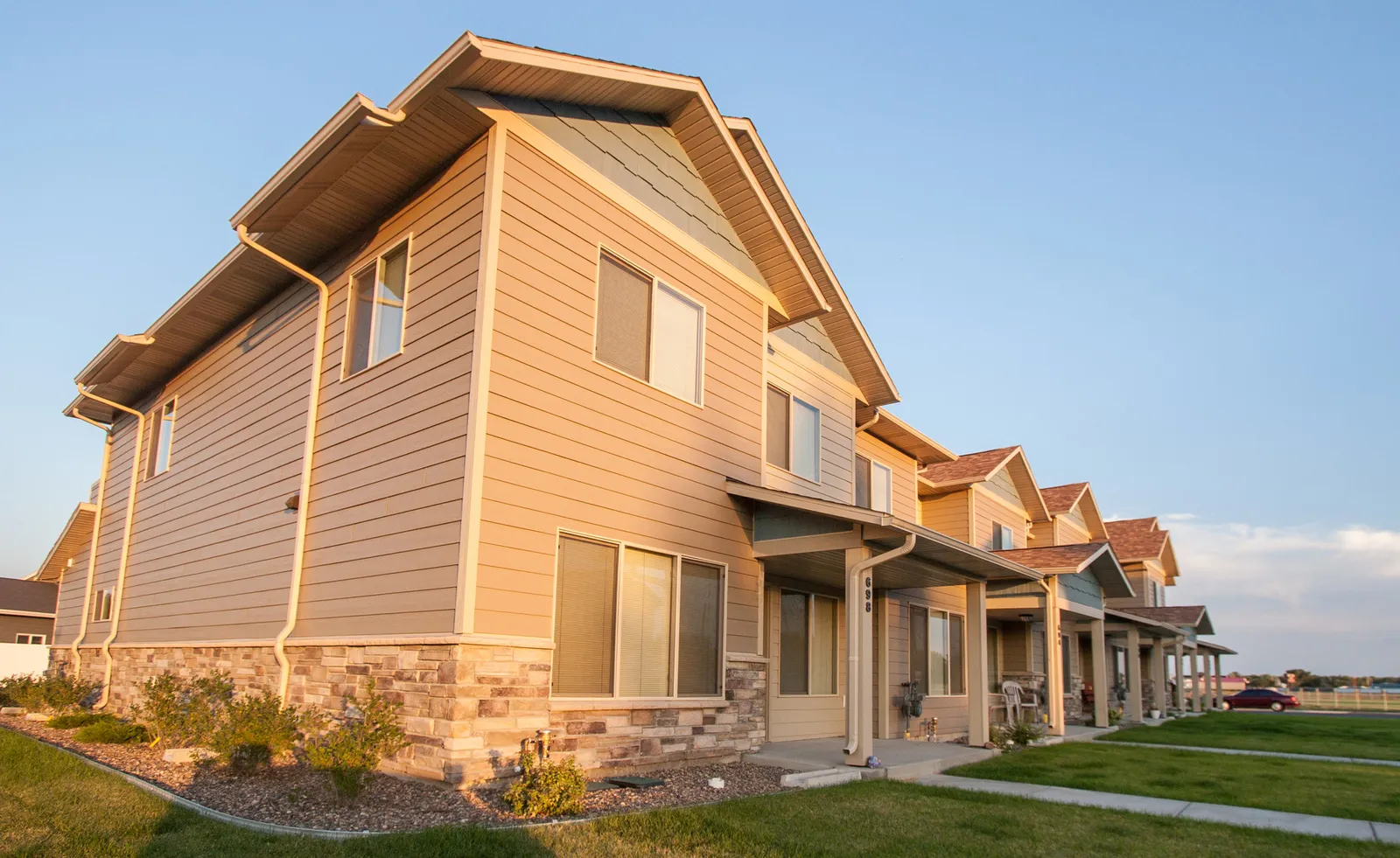 Multi-family residential buildings with modern design and landscaping.