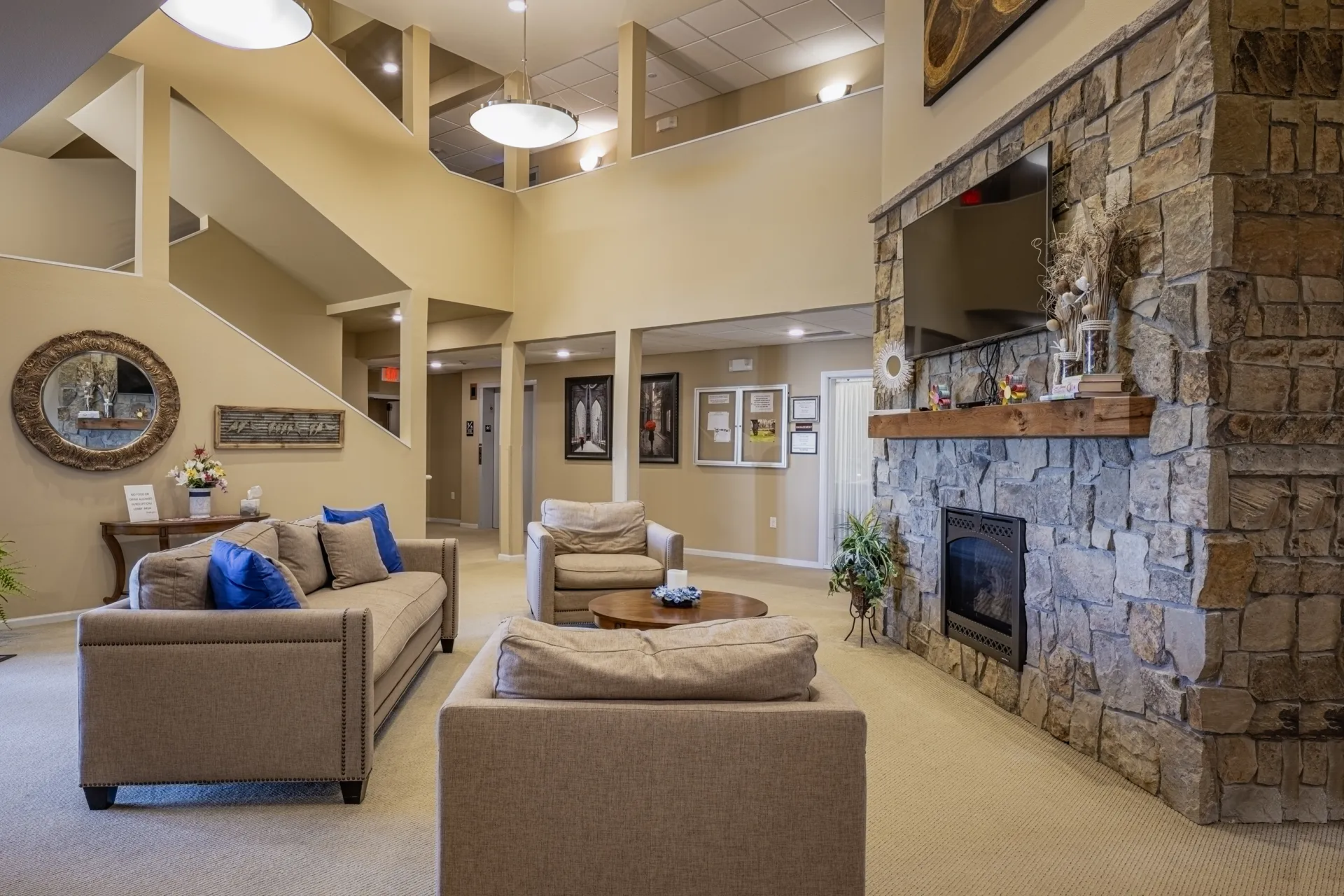 Spacious living room featuring a stone fireplace, comfortable sofas, and elegant decor for a warm, i.
