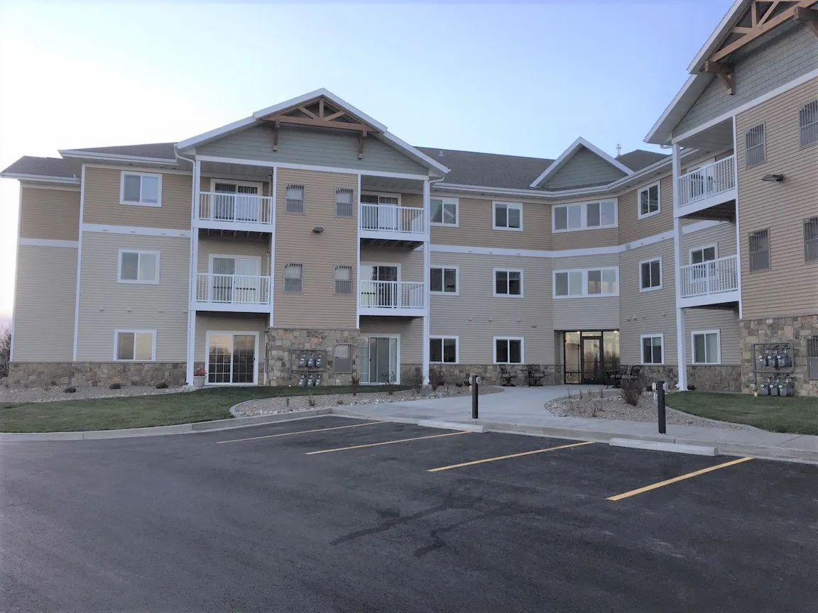 Apartment building with landscaped grounds and parking area.