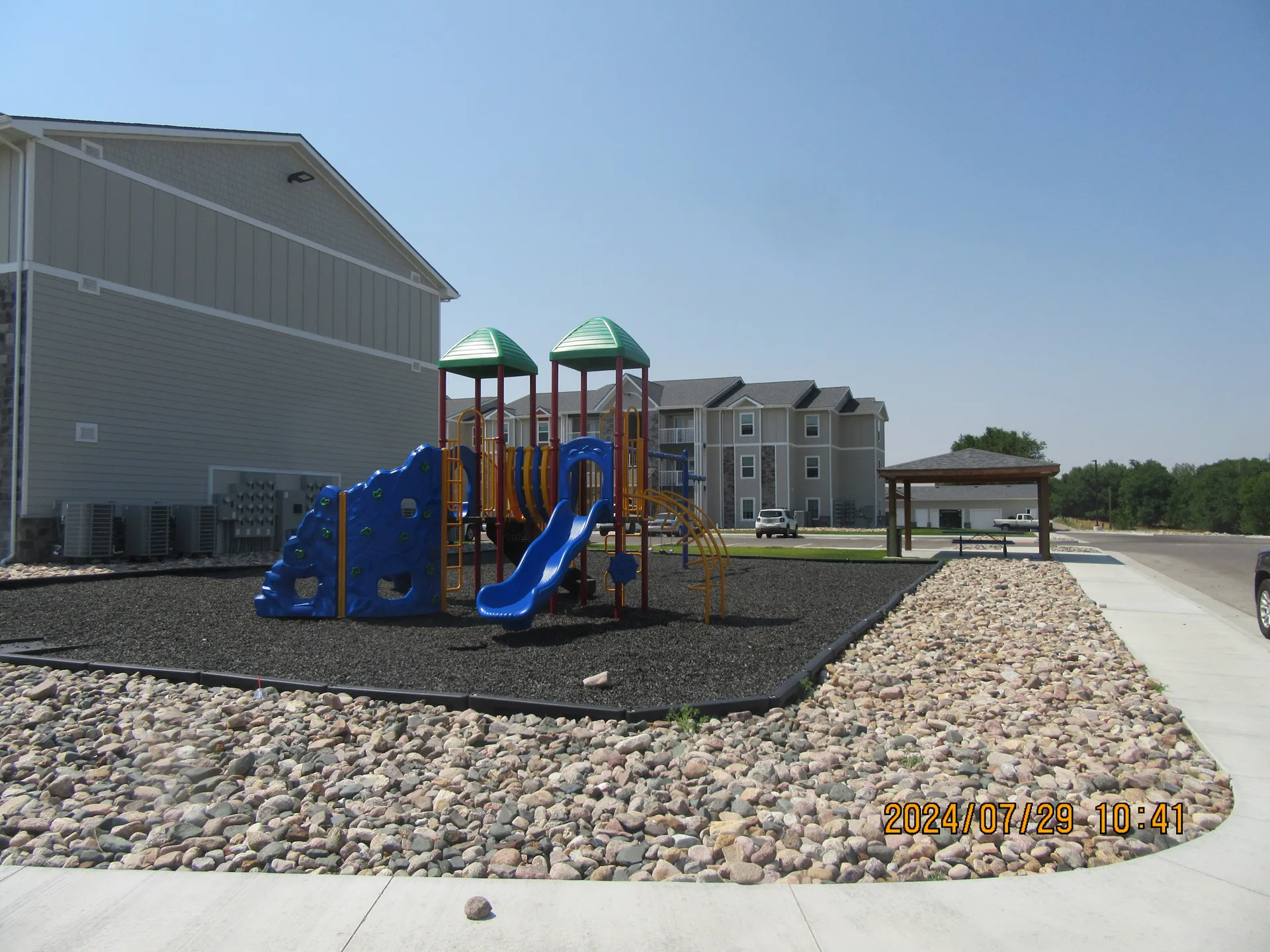 Playground with slides and climbing structures in a residential area.